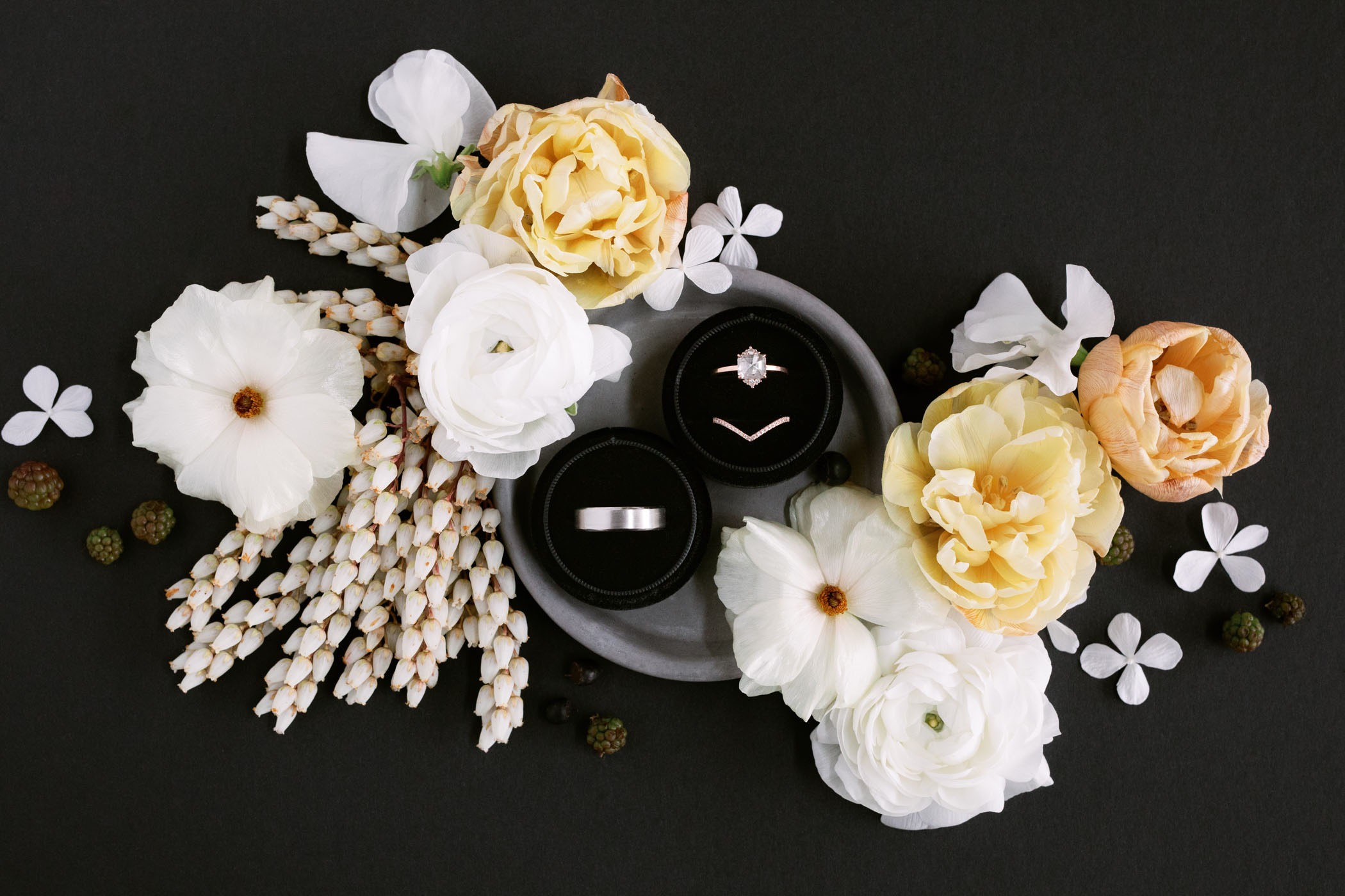 flat lay image with neutral florals of mens white gold wedding bands